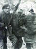Two captured Airborne troops help a wounded comrade