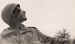 A soldier looks up at the sky, presumably during a resupply drop