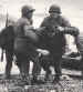 Soldiers help the survivors of a sunk landing craft ashore